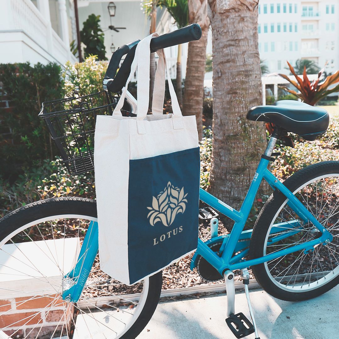 A bicycle with a branded tote bag hanging from the handle